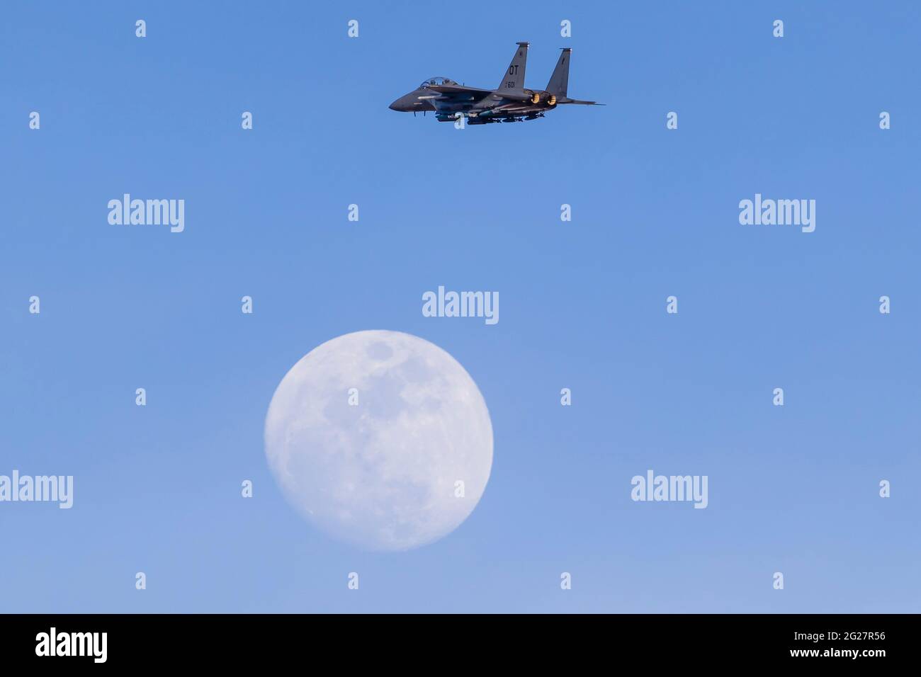 Una US Air Force F-15E Strike Eagle sale oltre la luna mentre parte. Foto Stock