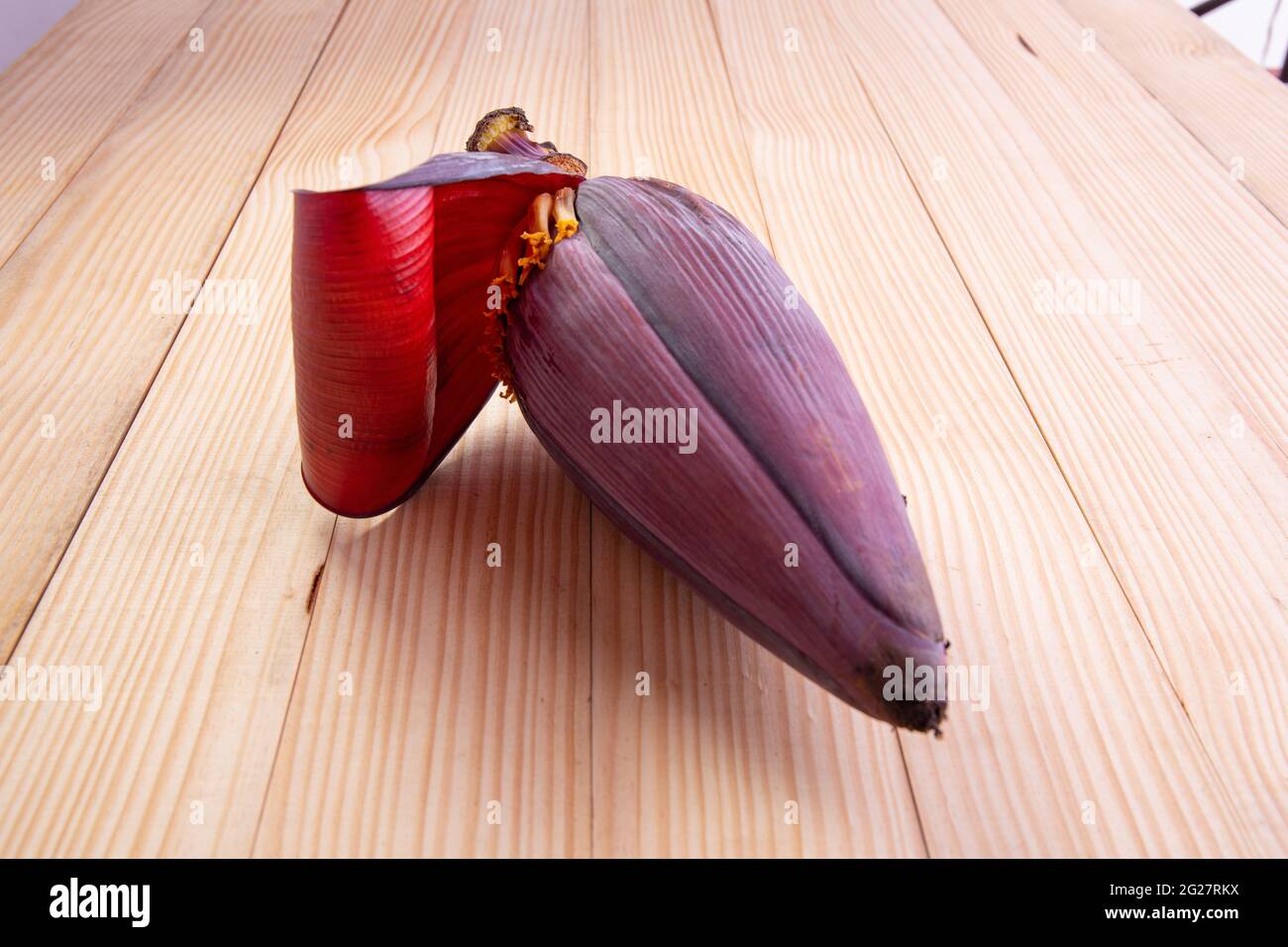 Fiori freschi di Banana o di Banana, ortaggi commestibili utilizzati principalmente nel sud-est asiatico, disposti su tavola testurizzata di legno Foto Stock
