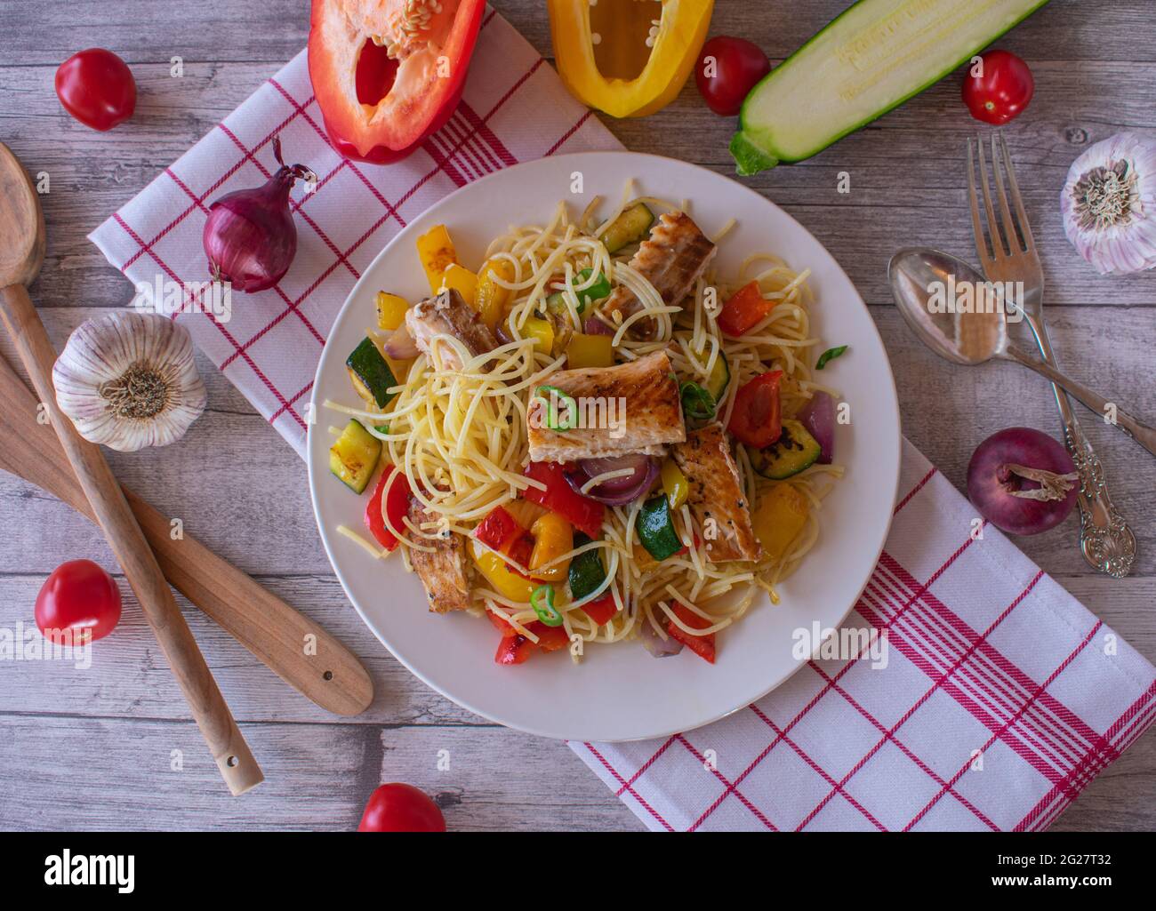 Piatto di pasta senza glutine con pesce e verdure su sfondo rustico e in legno Foto Stock
