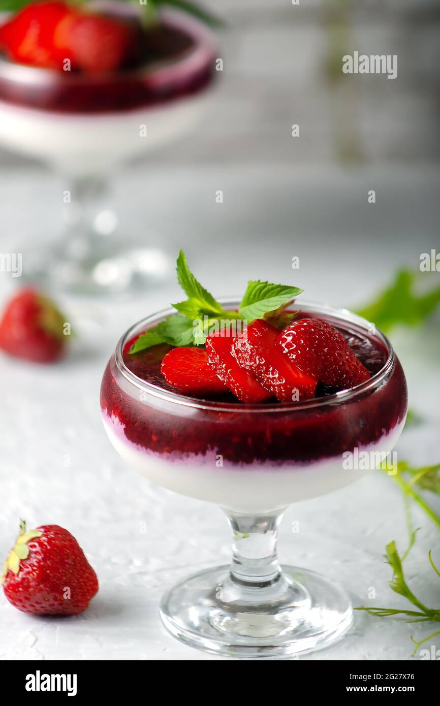 Tradizionale dessert italiano alla vaniglia panna cotta alla fragola in verina con frutti di bosco freschi. Spazio di copia. Foto Stock