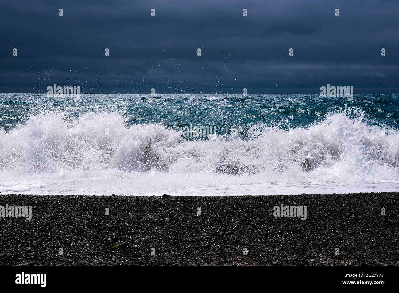 Incredibile onda di mare sulla costa di sabbia nera. Foto Stock