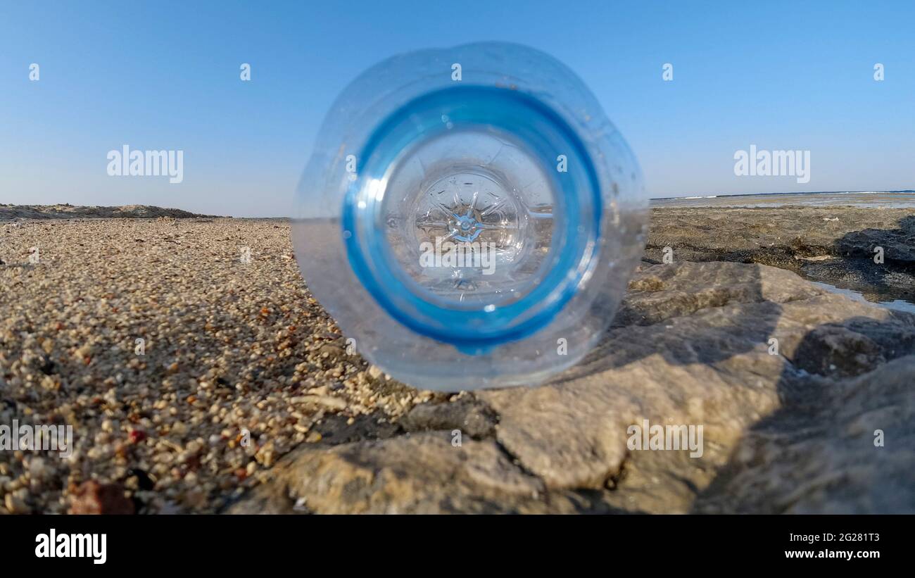Bottiglia collo primo piano in una giornata di sole sulla spiaggia. Problemi di plastica Foto Stock