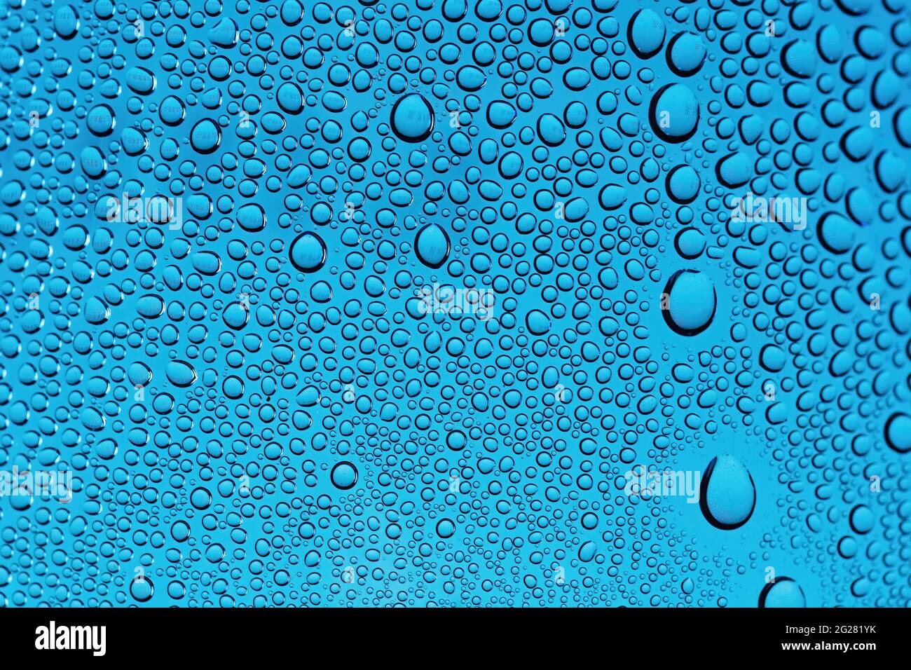Gocce d'acqua su sfondo blu da vicino. Foto Stock