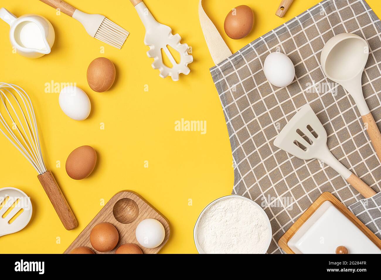 Ingredienti da forno e utensili da cucina con spazio di copia su sfondo giallo. Modello per cucinare ricette o il vostro disegno. Vista dall'alto, disposizione piatta. Foto Stock