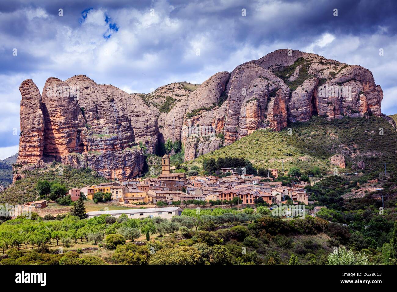 Il Mallos de Aguero si trova dietro il villaggio con lo stesso nome. Impressionanti rocce rosse con pareti verticali, molto apprezzate dagli scalatori. Spagna. Foto Stock