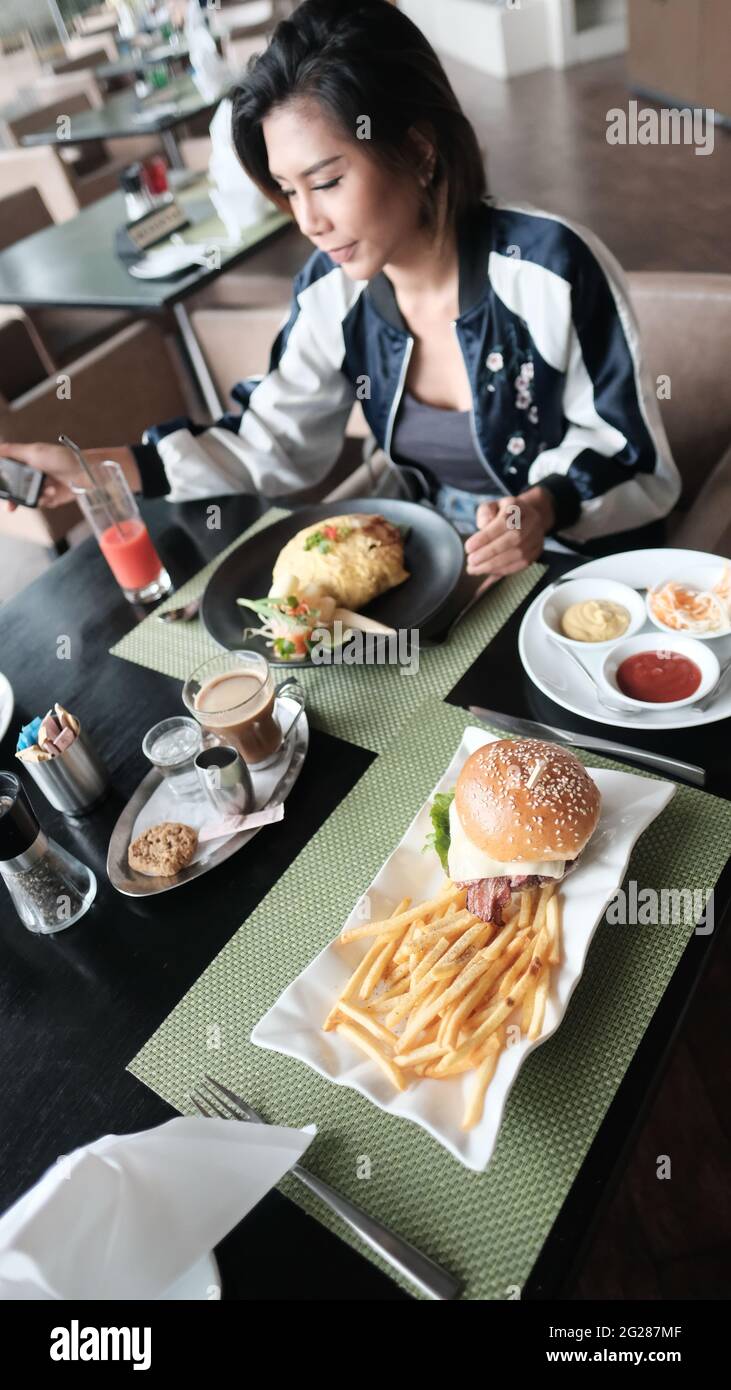Young Lady mangiare fuori ristorante informale a cinque stelle mangiare un pasto Foto Stock