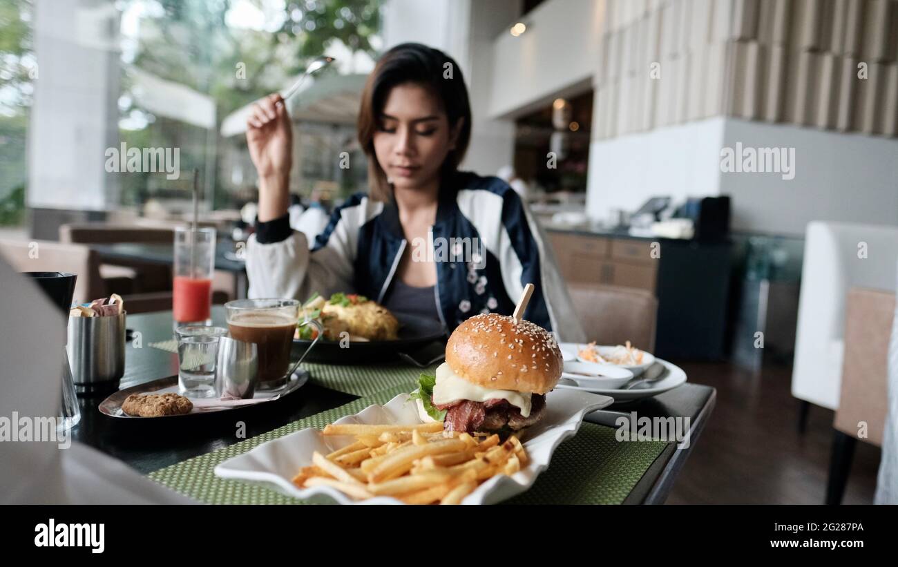 Young Lady mangiare fuori ristorante informale a cinque stelle mangiare un pasto Foto Stock