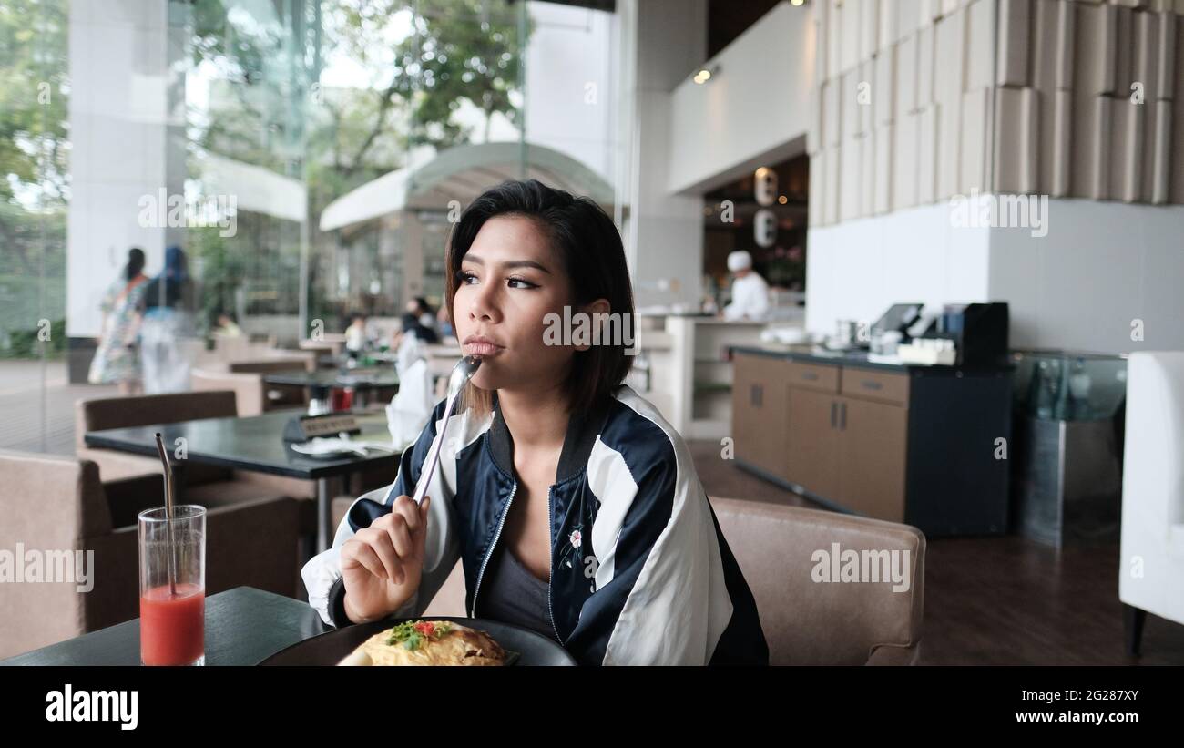 Young Lady mangiare fuori ristorante informale a cinque stelle mangiare un pasto Foto Stock