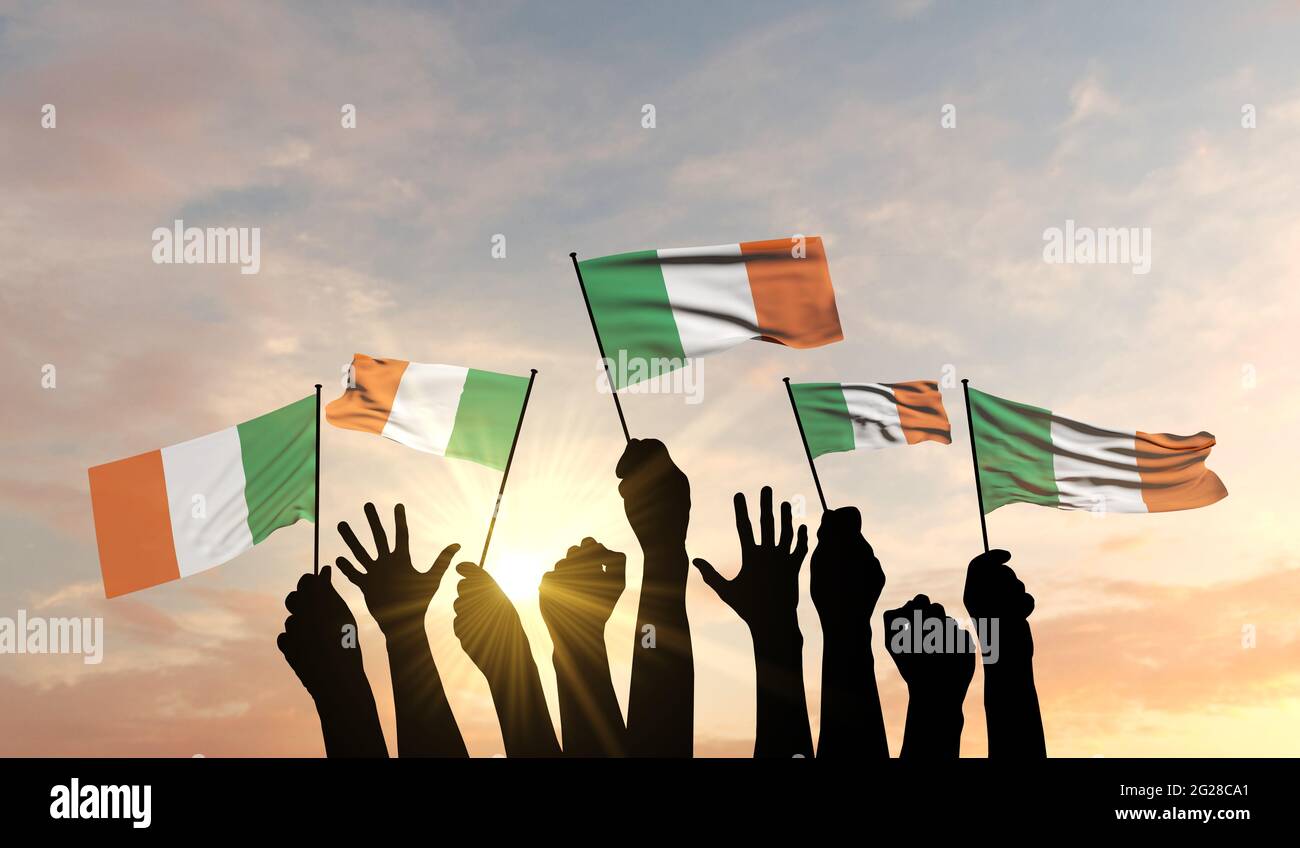 Silhouette di armi rialzate sventolando una bandiera irlandese con orgoglio. Rendering 3D Foto Stock