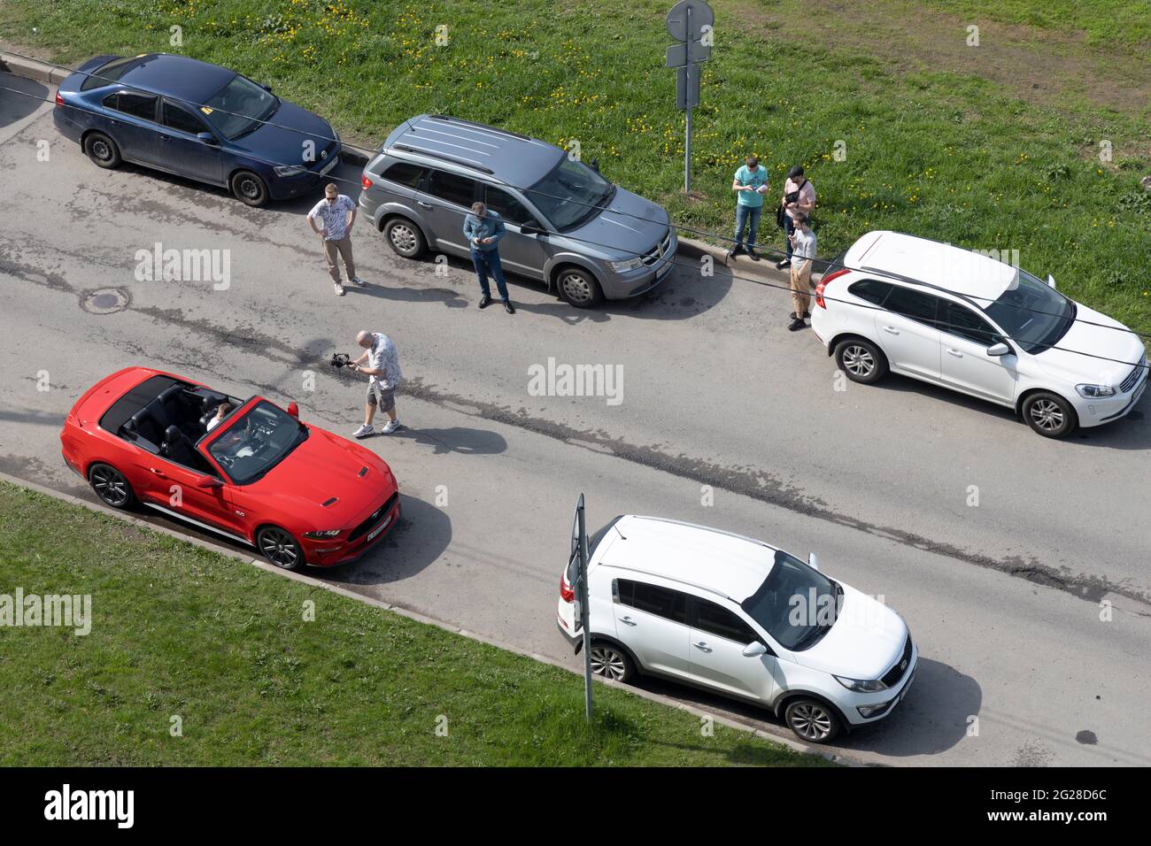 San Pietroburgo, Russia - 18 maggio 2021: Videografo con assistenti rimuove il conducente al volante della vettura ' Ford Mustang' vista dall'alto Foto Stock