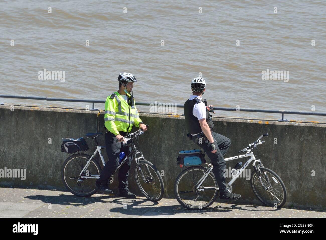 Due ufficiali di polizia da Newham MPS su una pattuglia in bicicletta che visita Gallions Point nella zona dei Royal Docks di Londra Foto Stock