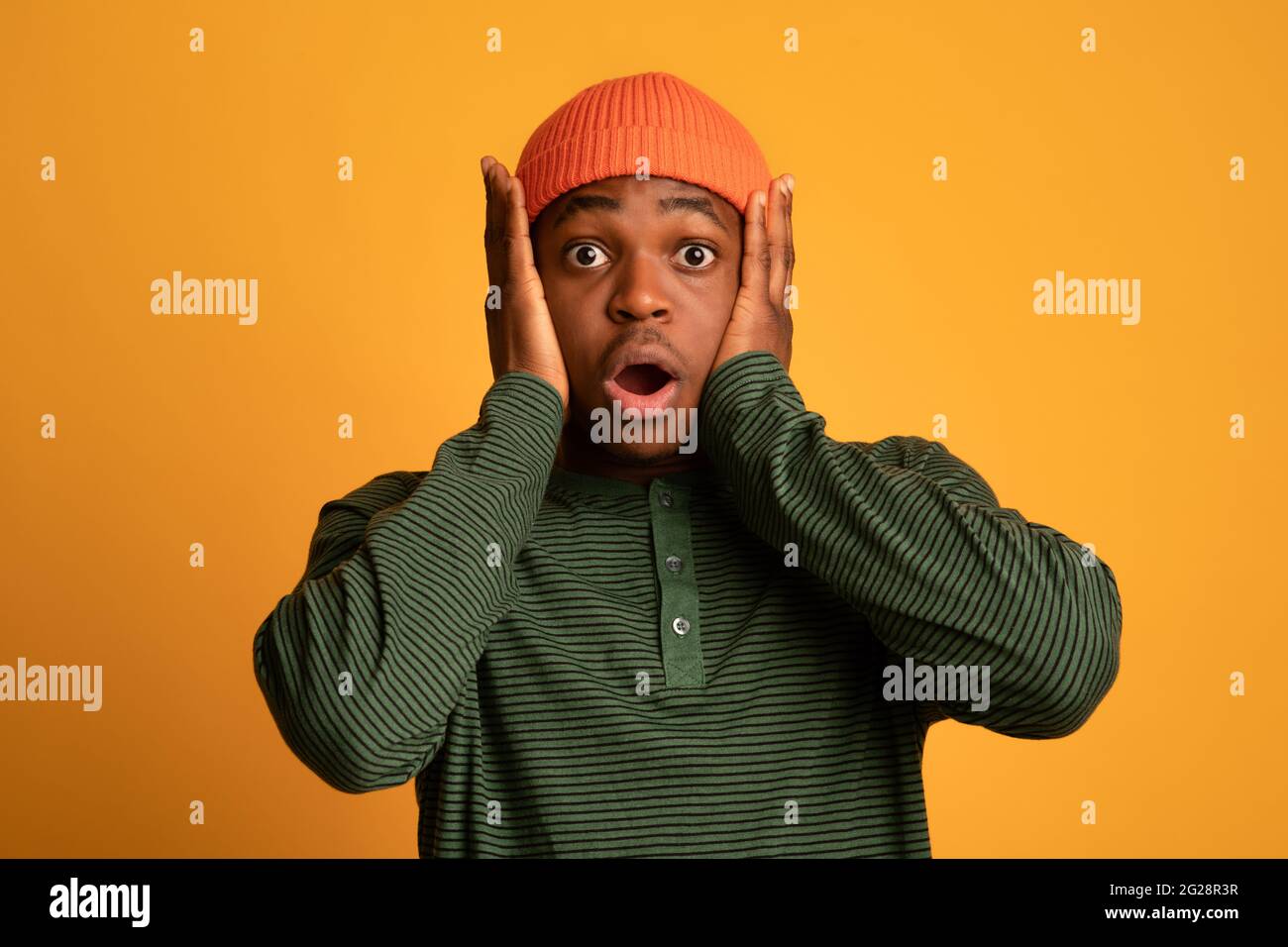 Ritratto di terrorizzato giovane uomo nero che tocca testa in shock Foto Stock