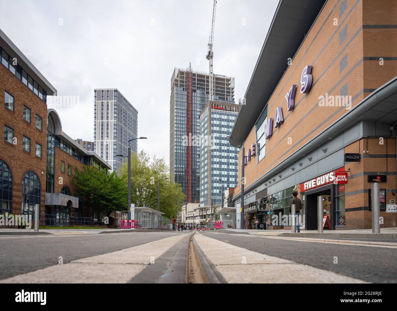 Birmingham Five Ways centro città basso livello drammatico angolo del centro città con torre residenziale blocchi raschiatori cielo e linee del tram che mostrano la vita quotidiana Foto Stock