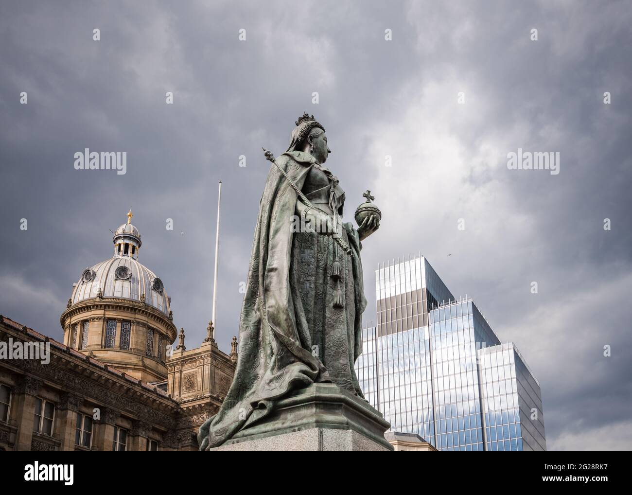 Statua della regina Victoria in Victoria Square, Birmingham Inghilterra Regno Unito. Municipio dietro e statua di bronzo su zoccolo di pietra. Skyline suggestivo e moderno Foto Stock