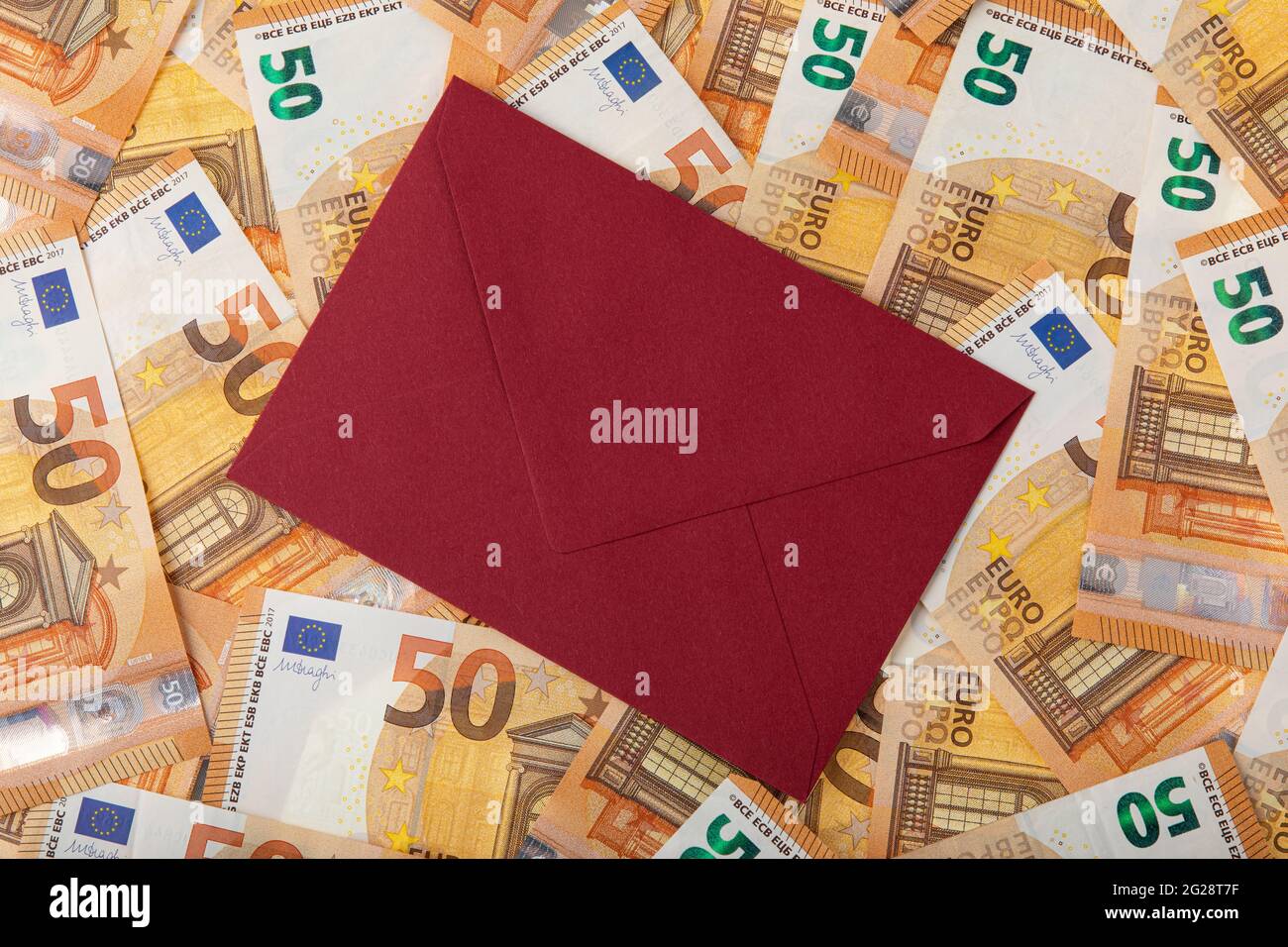 Sfondo pieno di cinquanta banconote in euro e busta su quel contante Foto Stock