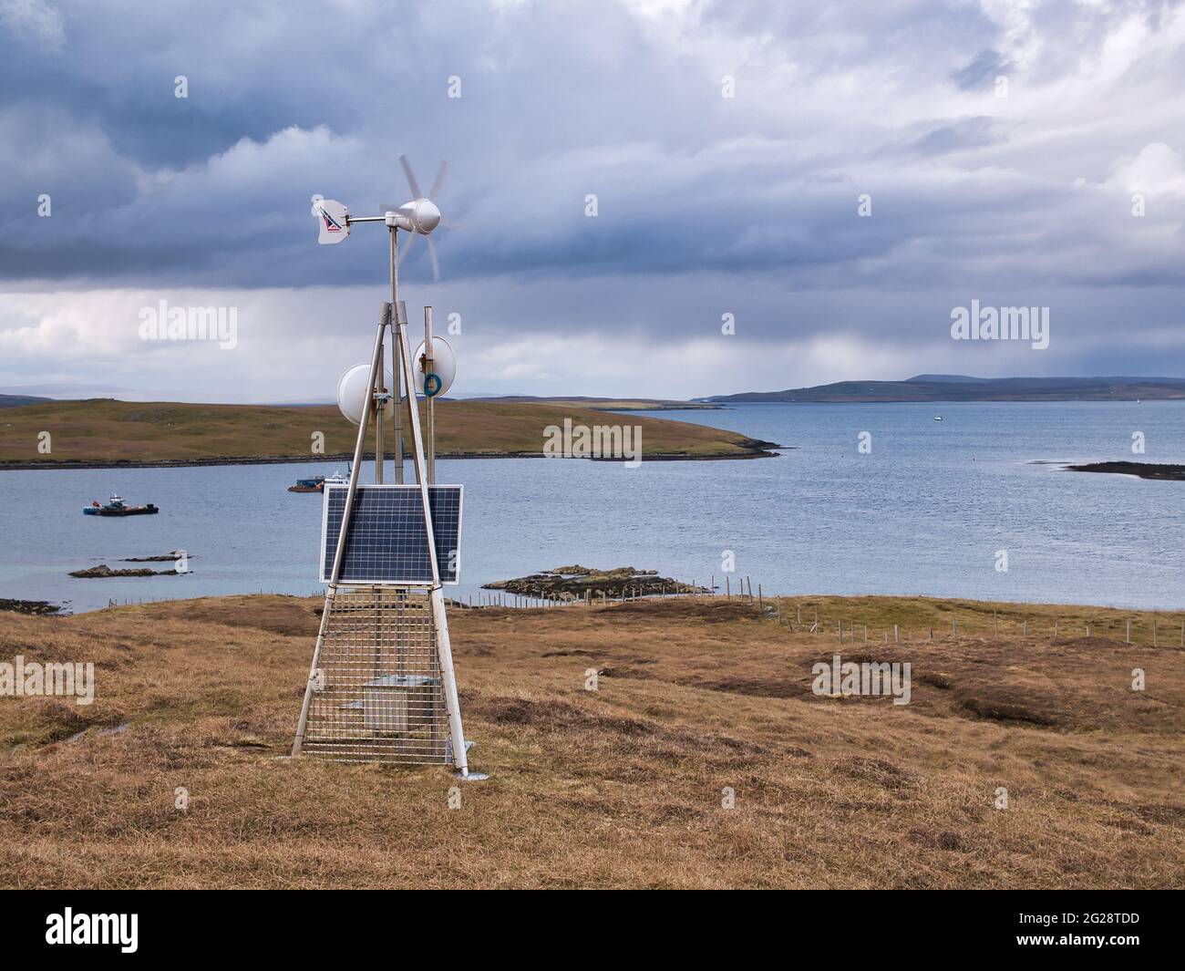 Una stazione di trasmissione dati a microonde alimentata da una turbina eolica e solare sulla brughiera aperta di Lunna Ness, Shetland, Regno Unito Foto Stock