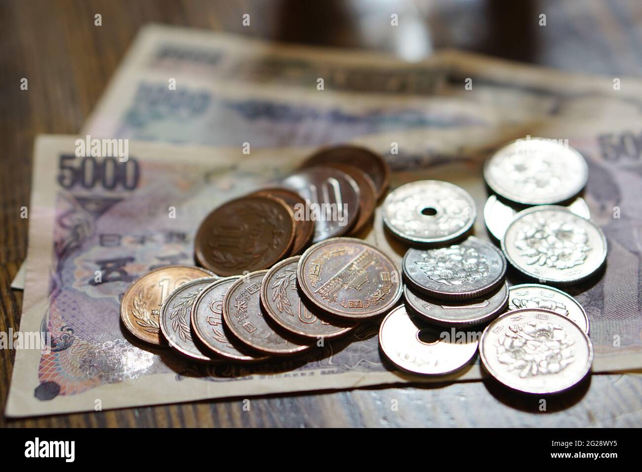 Moneta giapponese isolata (yen) con i suoi simboli asiatici sotto forma di monete e banconote su sfondo bianco Foto Stock