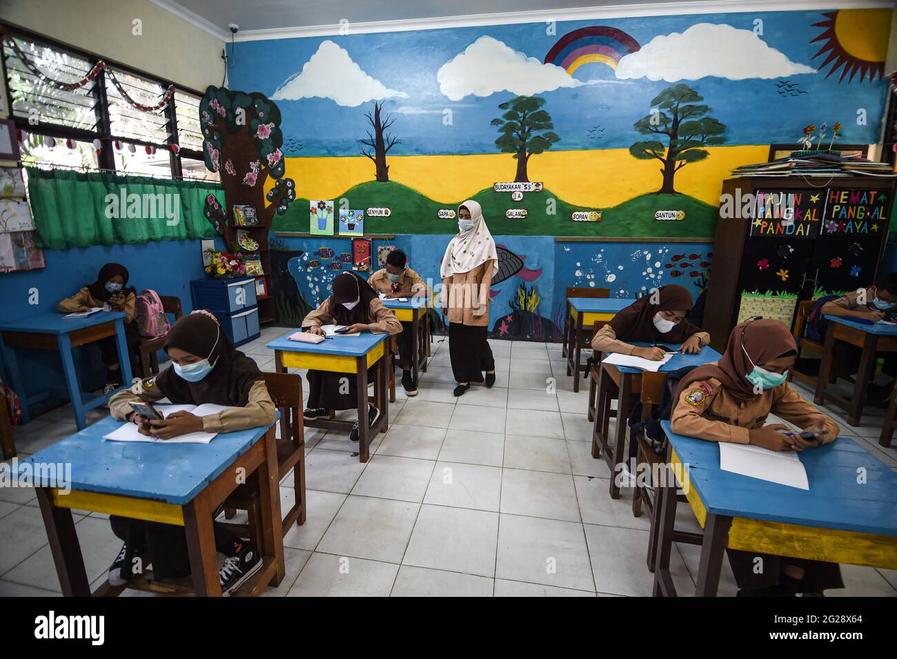 Giacarta, Indonesia. 9 Giugno 2021. Gli studenti elementari che indossano maschere facciali vengono visti in classe durante un'attività di apprendimento faccia a faccia in occasione dell'epidemia di COVID-19 in una scuola di Giacarta, Indonesia, il 9 giugno 2021. Credit: Agung Kuncahya B./Xinhua/Alamy Live News Foto Stock
