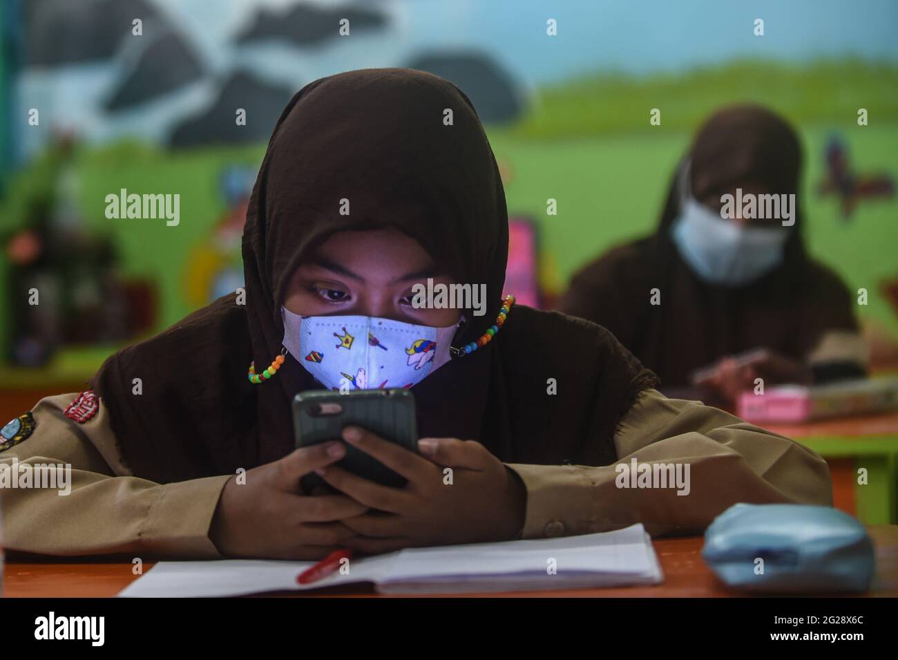 Giacarta, Indonesia. 9 Giugno 2021. Uno studente elementare che indossa una maschera facciale viene visto in classe durante un'attività di apprendimento faccia a faccia in occasione dell'epidemia di COVID-19 in una scuola di Giacarta, Indonesia, il 9 giugno 2021. Credit: Agung Kuncahya B./Xinhua/Alamy Live News Foto Stock