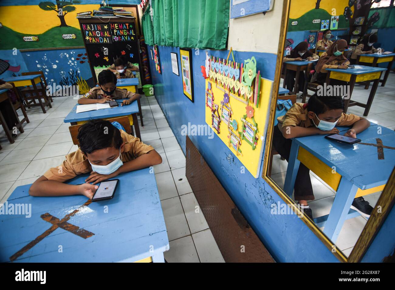 Giacarta, Indonesia. 9 Giugno 2021. Gli studenti elementari che indossano maschere facciali vengono visti in classe durante un'attività di apprendimento faccia a faccia in occasione dell'epidemia di COVID-19 in una scuola di Giacarta, Indonesia, il 9 giugno 2021. Credit: Agung Kuncahya B./Xinhua/Alamy Live News Foto Stock