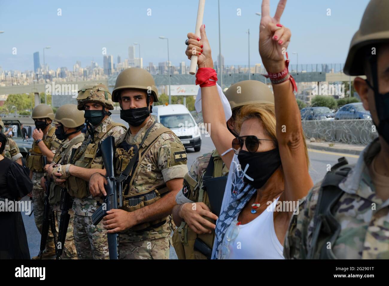 Donna libanese si trova nel mezzo di una linea militare vicino al palazzo presidenziale di Baabda. Partecipa alla rivolta della rivoluzione dell'ottobre 17 Foto Stock