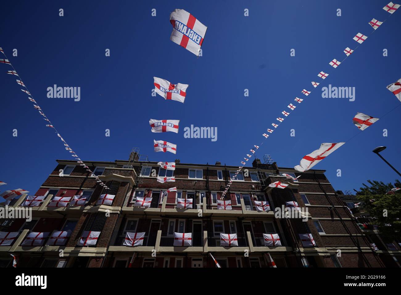 Le bandiere inglesi hanno messo in su sulla tenuta di Kirby a Bermondsey, Londra del sud, dove i residenti stanno mostrando il loro sostegno all'Inghilterra prima della partita della nazione di 2020 euro la domenica. Data immagine: Mercoledì 9 giugno 2021. Foto Stock