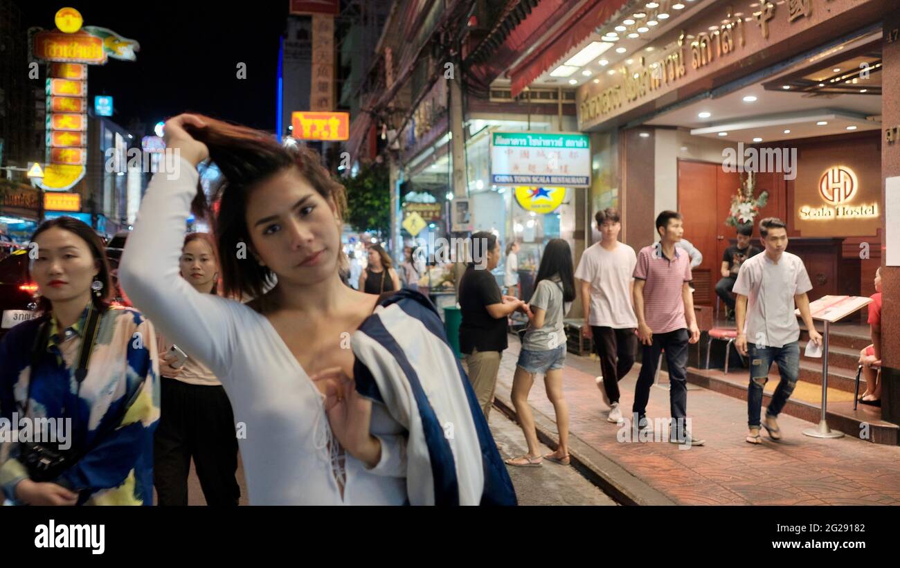 Super modello indossando blusa con le persone sullo sfondo su Yaowarat Road Chinatown Bangkok Thailandia Foto Stock