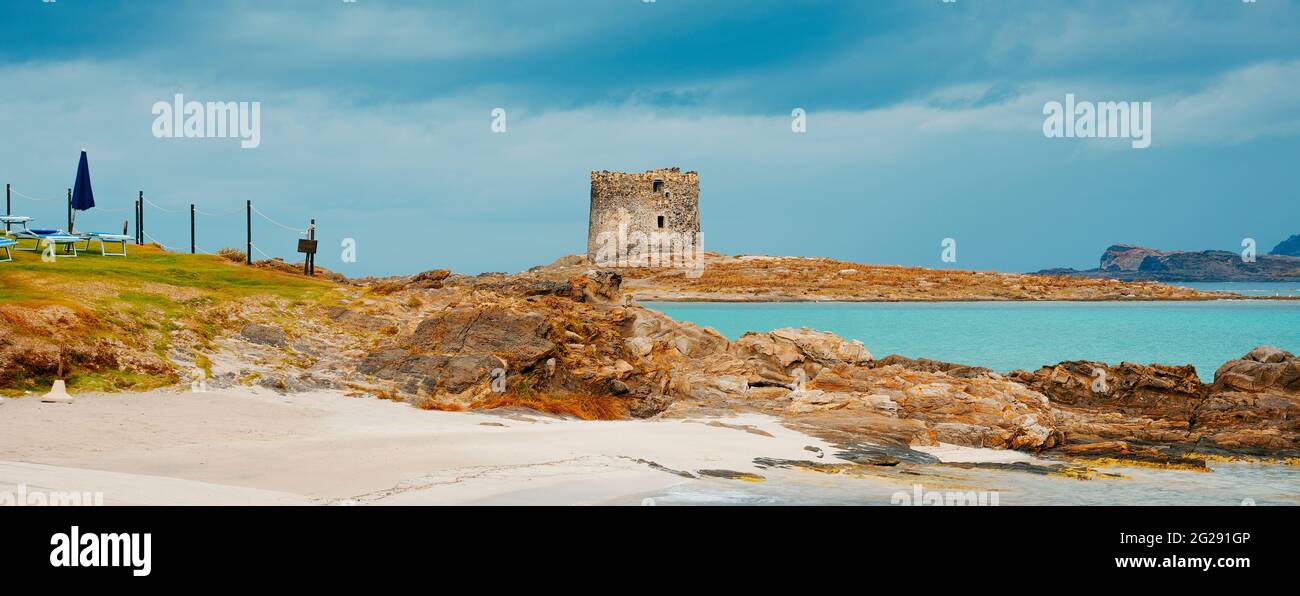 Una vista sulla spiaggia della Pelosa in Sardegna, con la torre della Pelosa e l'isola piana sullo sfondo, in un punto di vista Foto Stock