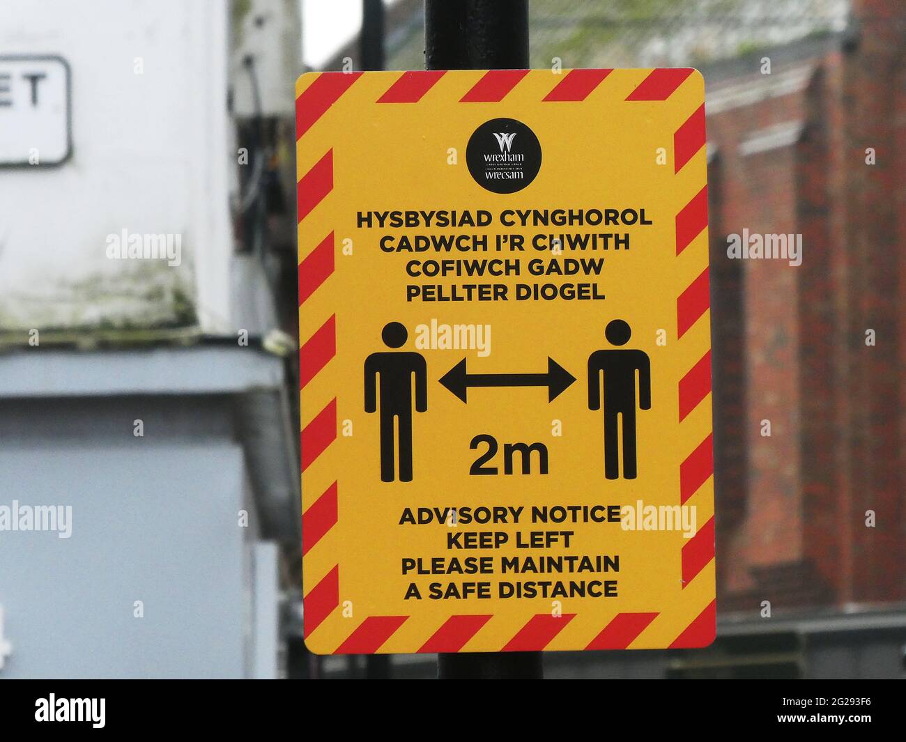 Segnali di avvertimento nel centro di Wrexham durante la pandemia. Segno di allontanamento sociale Foto Stock