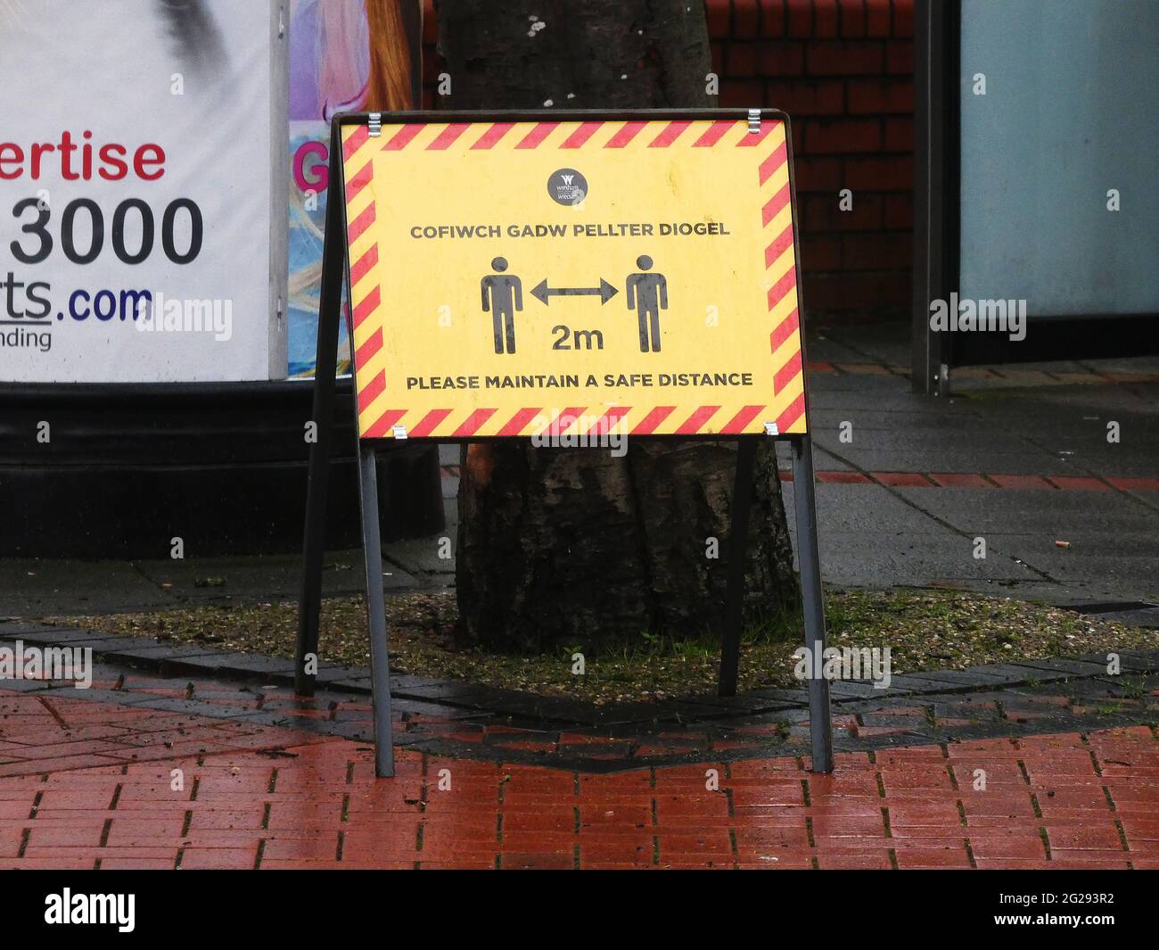 Coronavirus Covid 19 - segnali di avvertimento nel centro di Wrexham durante la pandemia. Segno di allontanamento sociale Foto Stock