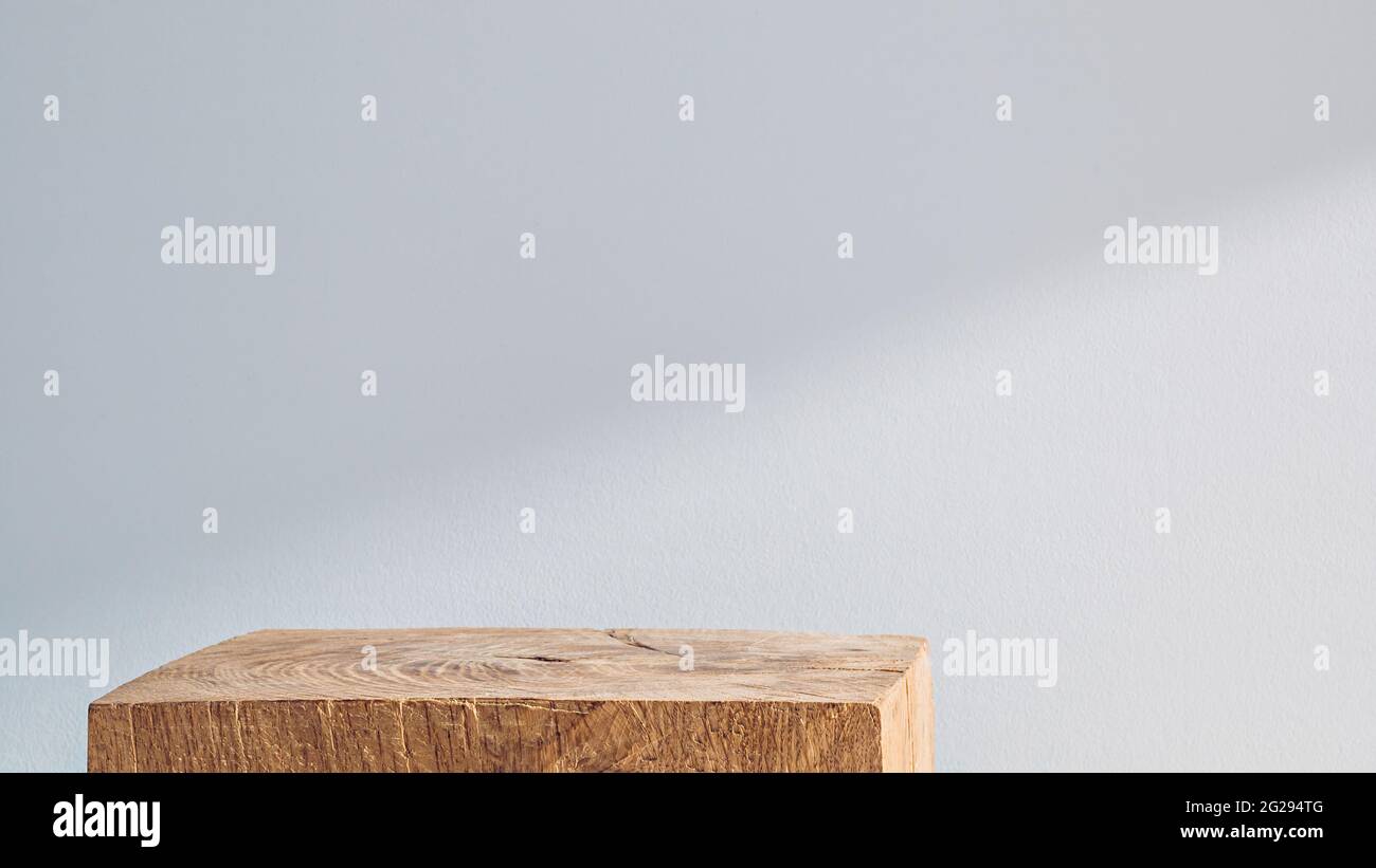 Podio cubico in legno su sfondo bianco con ombra Foto Stock