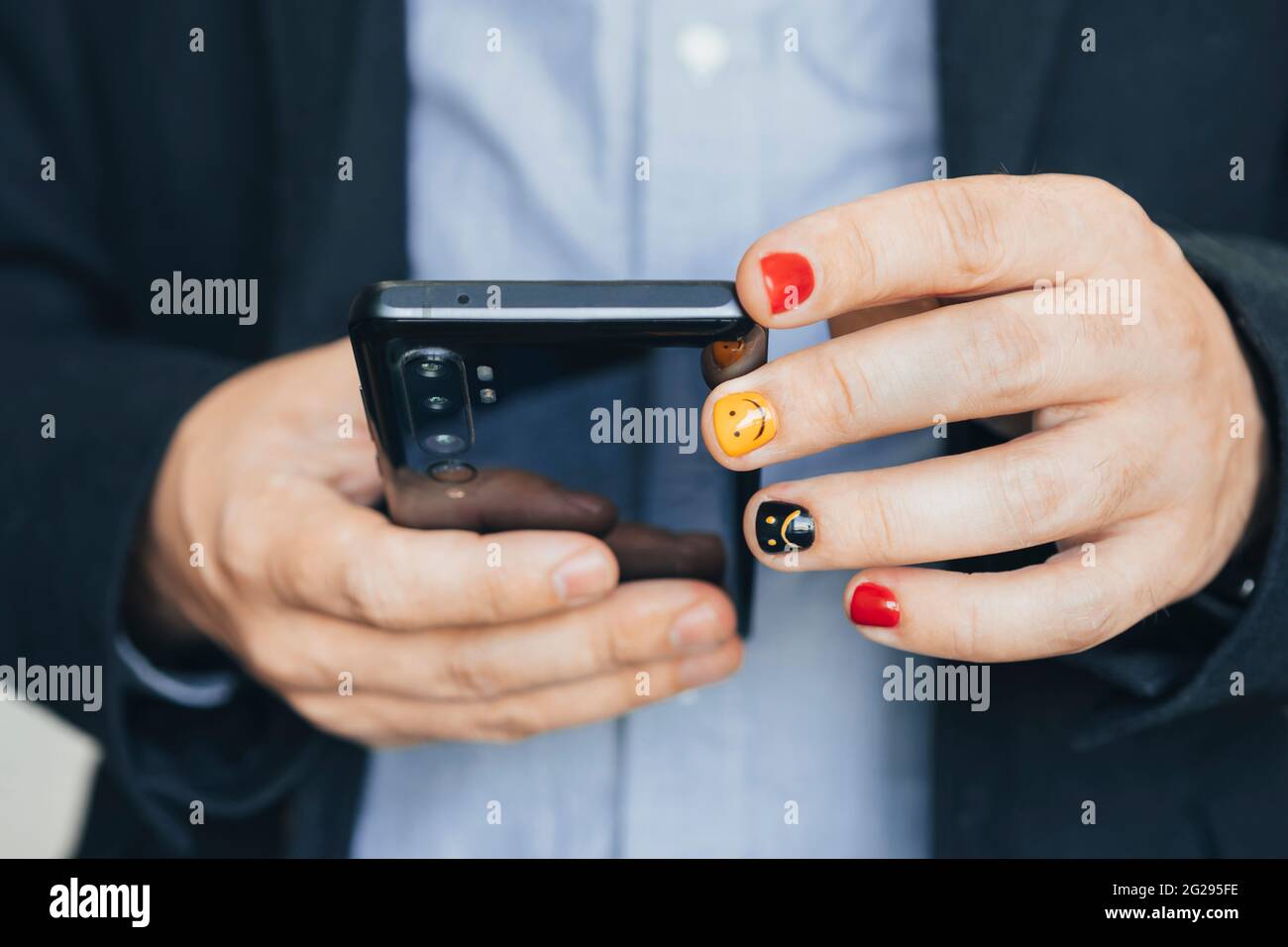 Primo piano di un uomo d'affari occasionale con smartphone mobile, lettura di aggiornamenti di notizie aziendali e report di marketing tramite app mobile. Uomo con chiodi dipinti. De Foto Stock