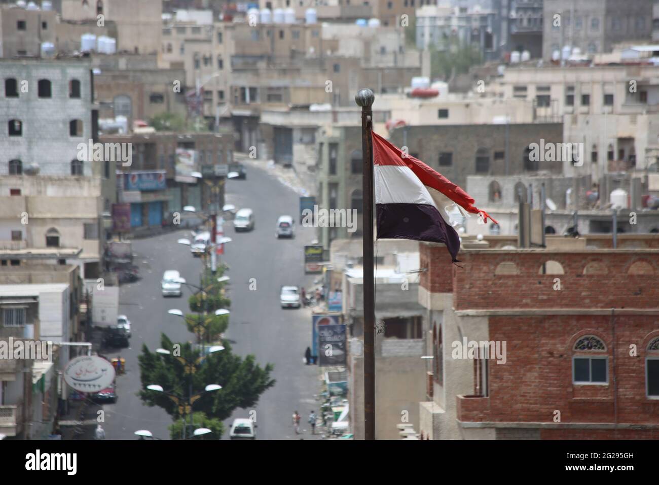 Taiz Yemen - 22 ago 2016 : bandiera yemenita di fronte a edifici distrutti dalla guerra sulla città di Taiz Foto Stock