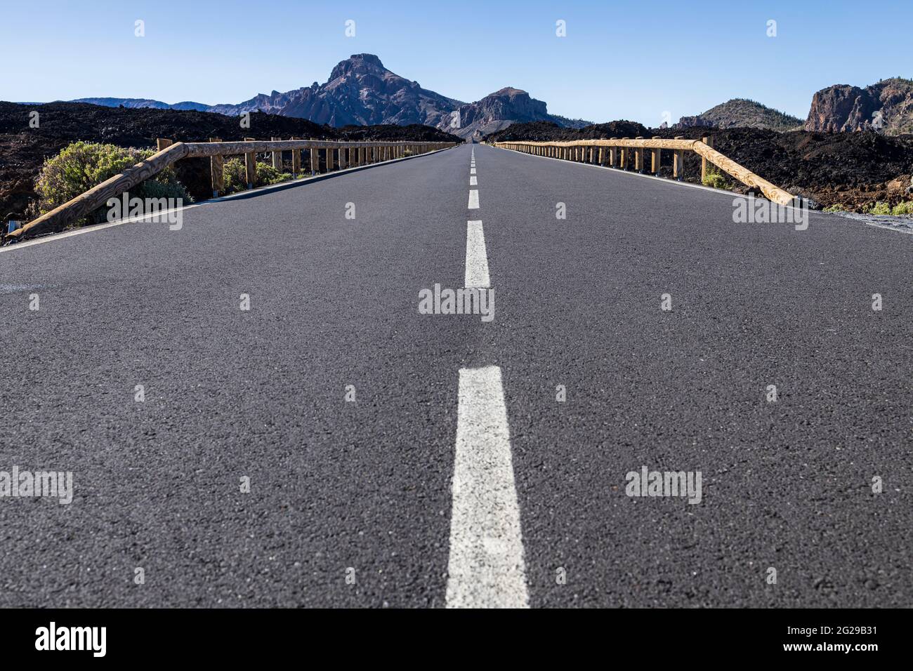 Vista ad angolo basso lungo la superficie asfaltata della strada TF38 attraverso il Parco Nazionale Las Canadas del Teide, Tenerife, Isole Canarie, Spagna Foto Stock
