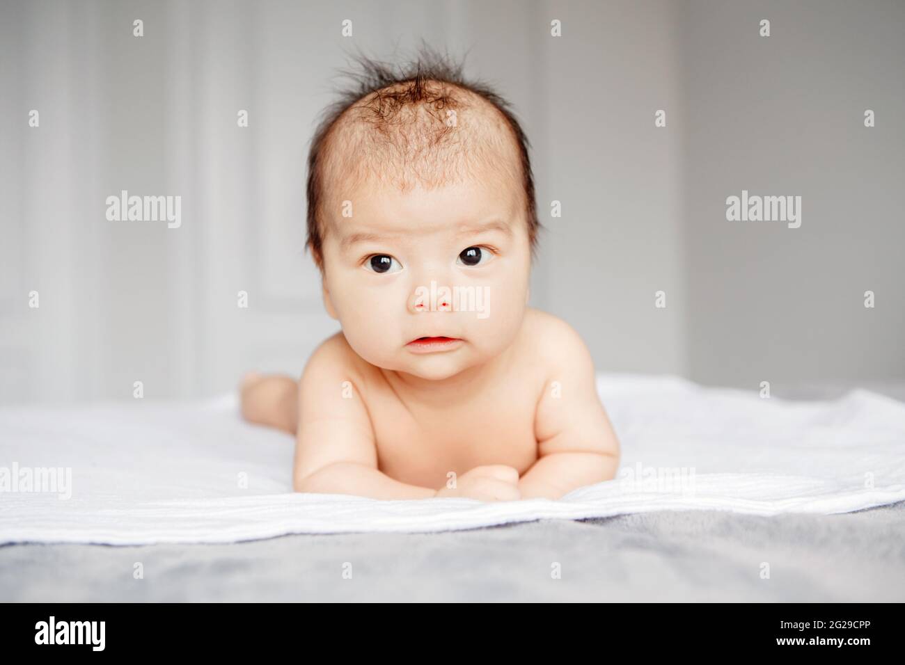 Closeup di adorabile informato allarme curioso asiatico cinese neonato bambino Foto Stock