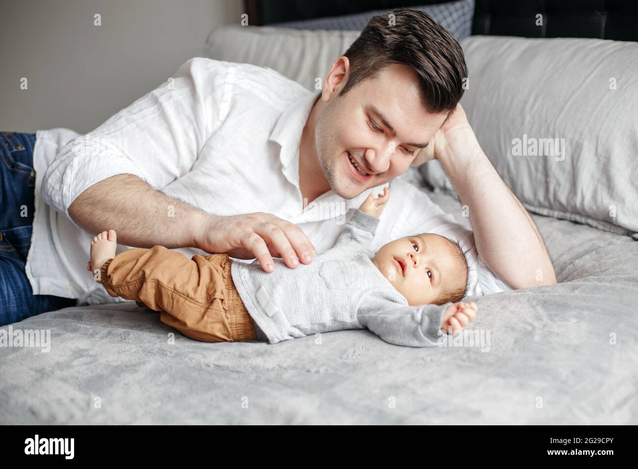 Festa dei padri. Papà felice orgoglioso giocare con il bambino neonato ragazzo. Foto Stock