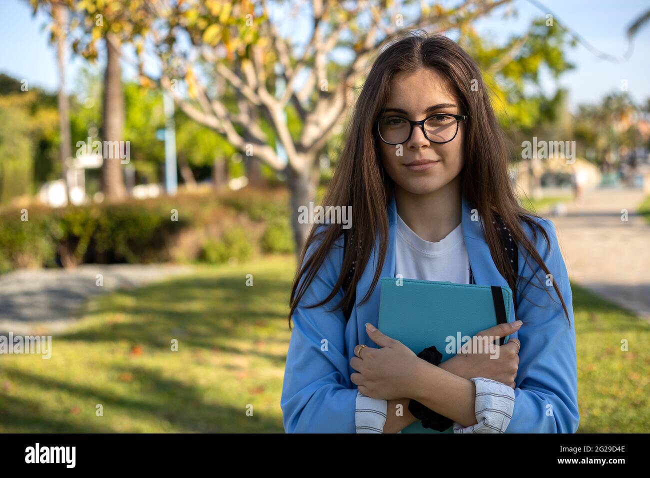 Ragazza studentesca che usa la tecnologia in giardino Foto Stock