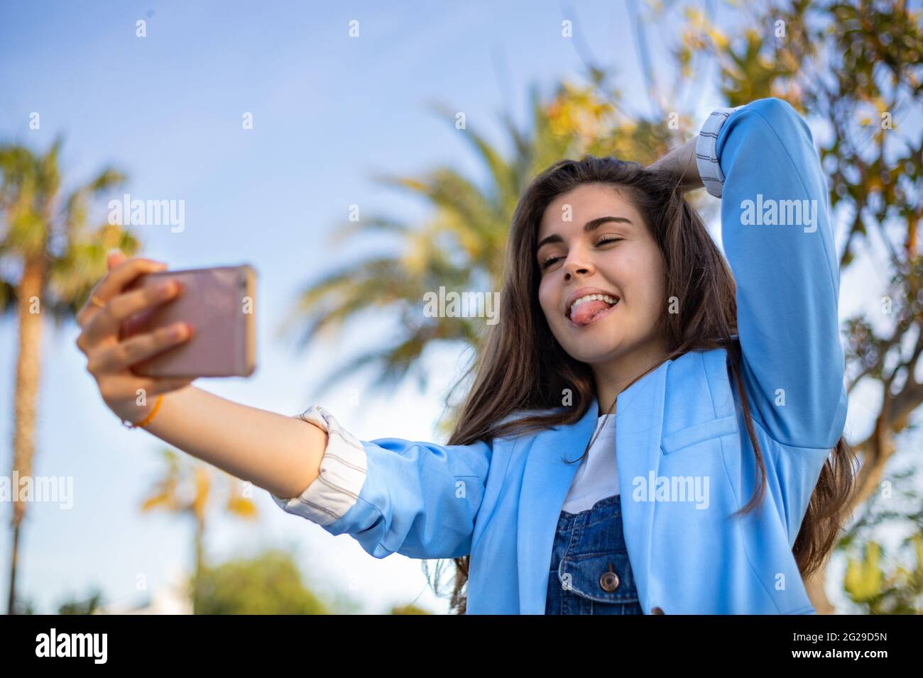 Ragazza studentesca che usa la tecnologia in giardino Foto Stock