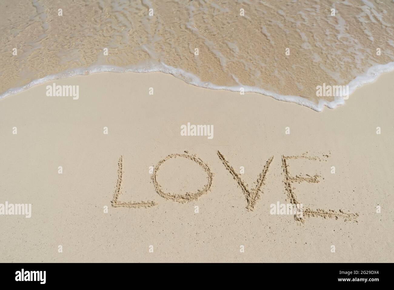 Il testo AMORE sulla sabbia di una spiaggia tropicale Foto Stock