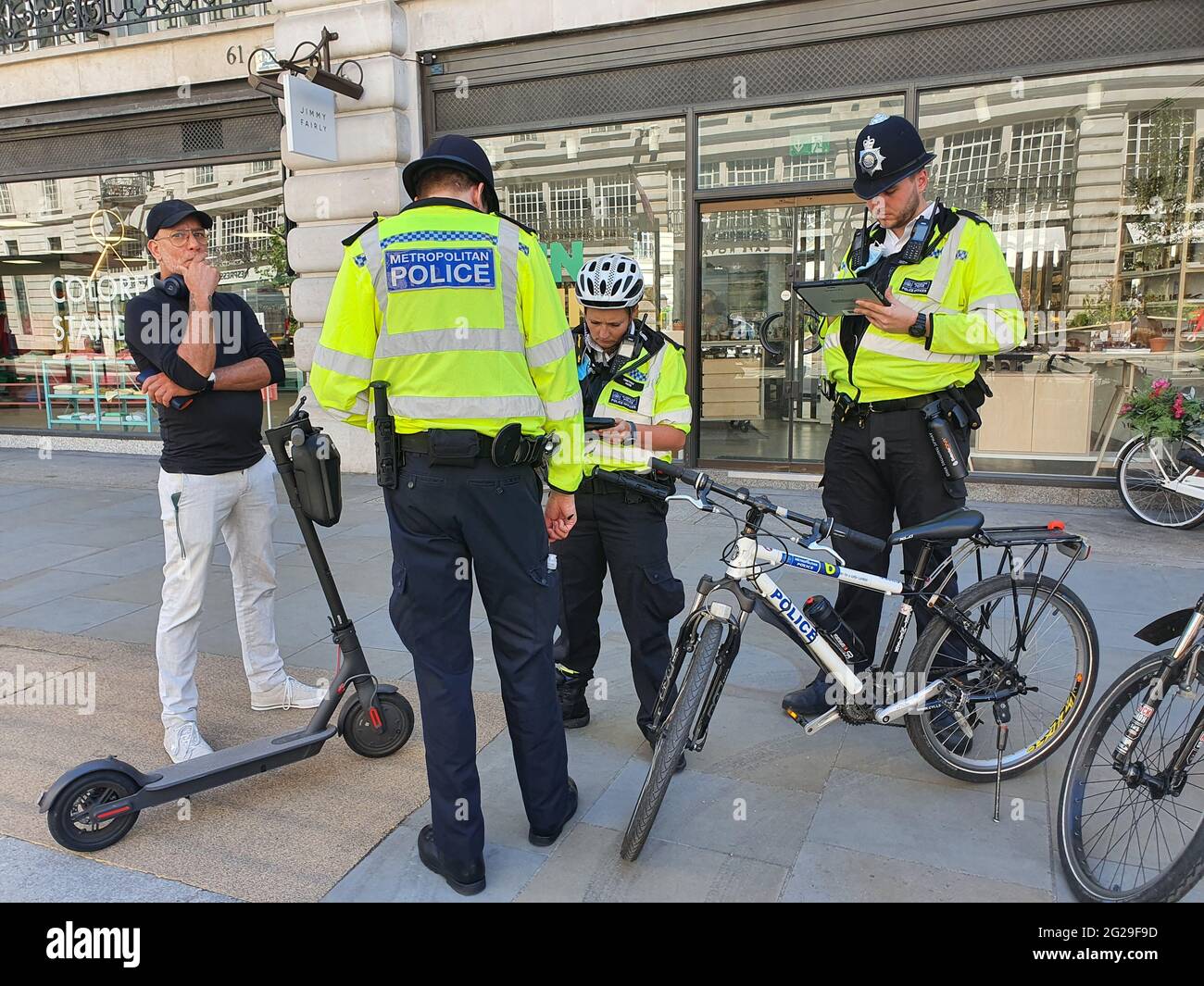 Londra, Regno Unito, 9 giugno 2021: Polizia su Regent Street belle persone catturate con scooter elettrici. Anche se alcuni quartieri londinesi stanno permettendo prove su scooter elettronico, in altri comuni non sono permessi. Sono sempre più popolari come opzione di trasporto verde, ma l'applicazione è irregolare e le regole sono sconcertanti per la maggior parte delle persone. Anna Watson/Alamy Notizie dal vivo Foto Stock