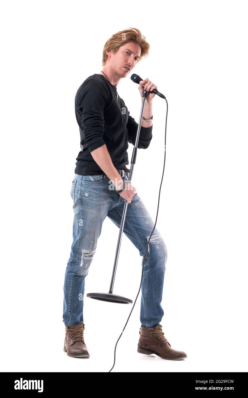 Vista laterale del cantante di musica macho rock uomo che canta sul microfono sul supporto. Lunghezza totale del corpo isolata su sfondo bianco. Foto Stock