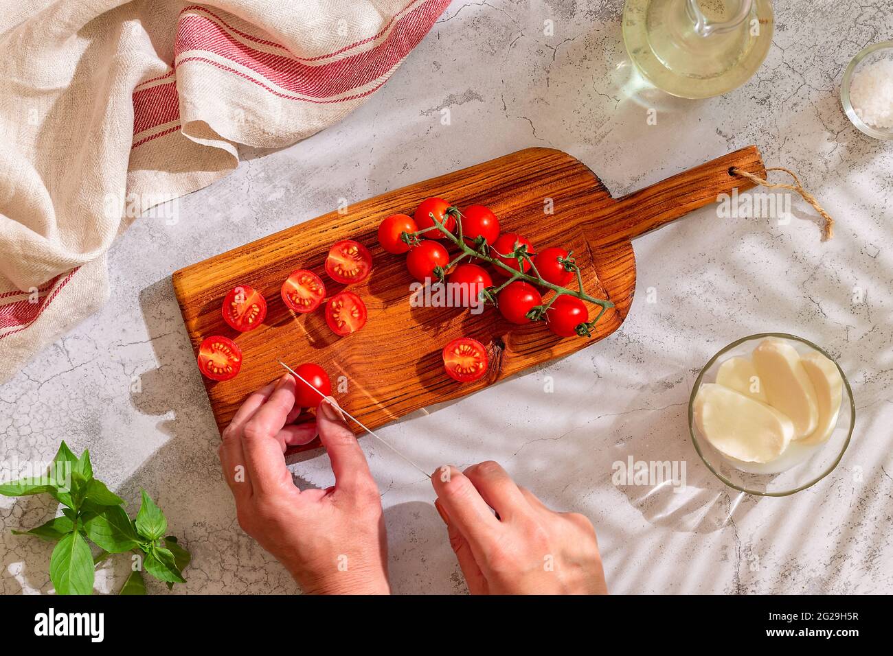 Tavola da cucina con pomodori interi e tagliati. Concetto di cucina casalinga, vista dall'alto. Foto Stock