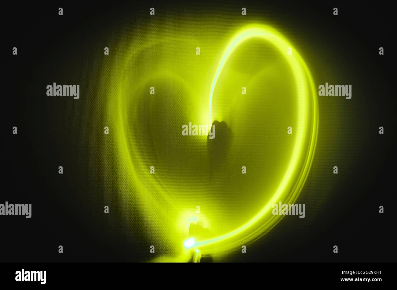 Pittura chiara del cuore in uno sfondo bianco della parete per la giornata dei valentines con il concetto di sentiero di luce gialla Foto Stock