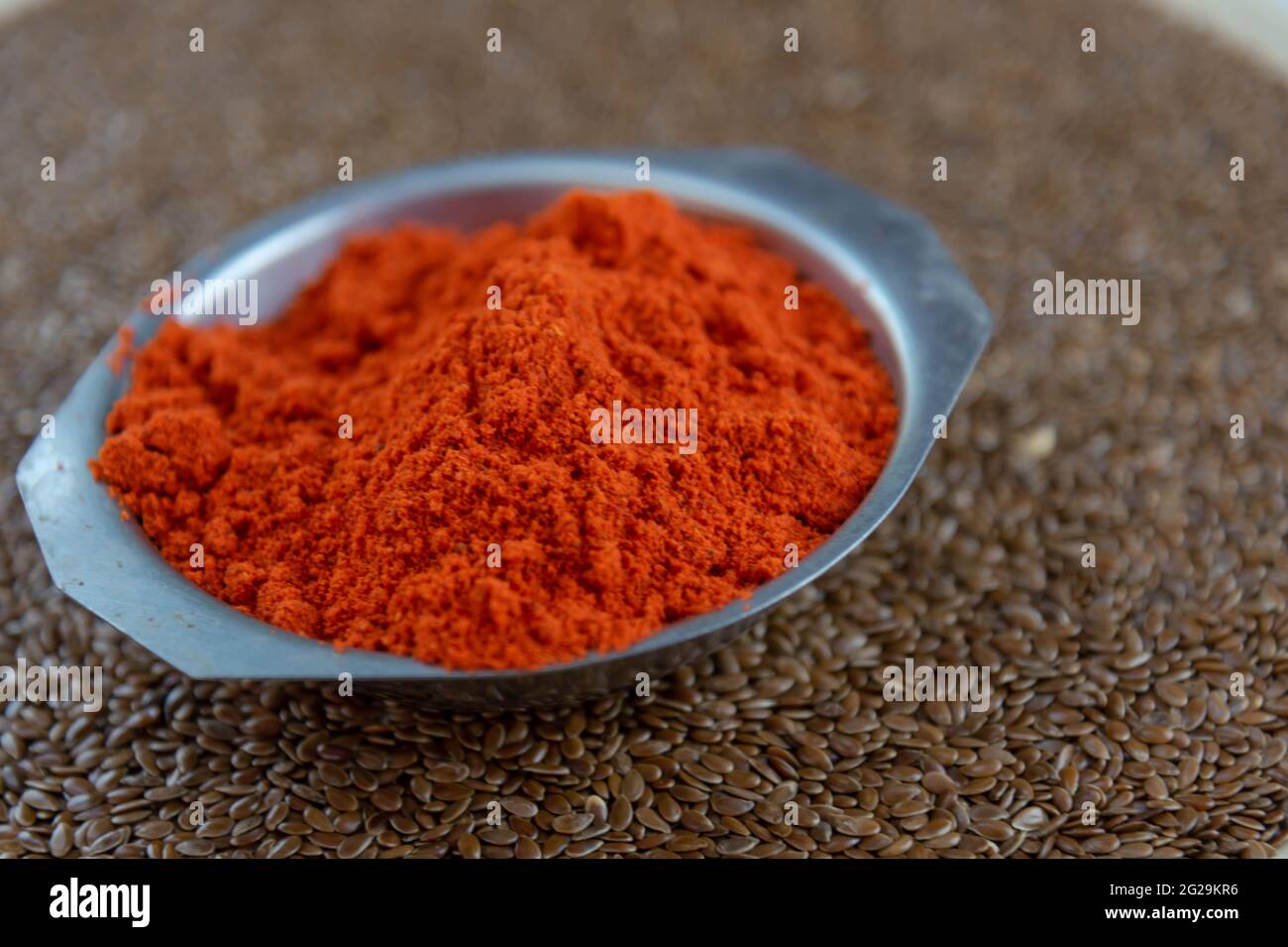 Condimento culinario di bixa orellana su semi di lino. La stagionatura di annatto, detta anche paprika, è comune nelle ricette culinarie europee. Spezie e stagionina Foto Stock