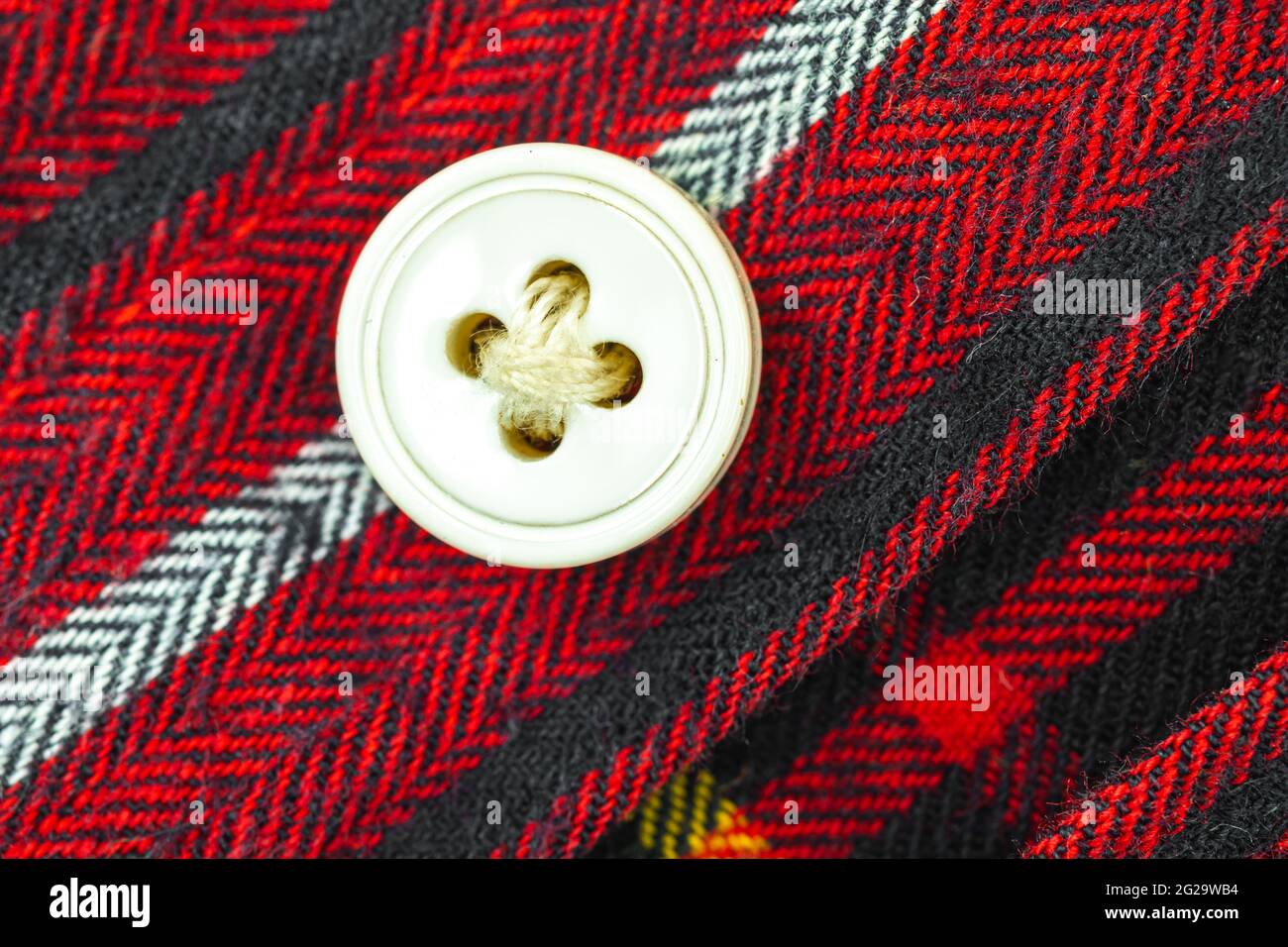 Bottone sulla camicia rossa sfondo texture camicetta Foto Stock