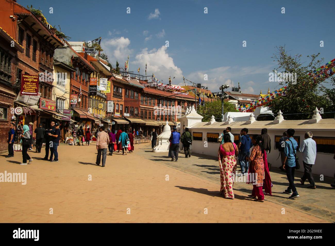 La gente passeggia per il grande stupa di Boudha e visita i negozi e i caffè locali. Foto Stock