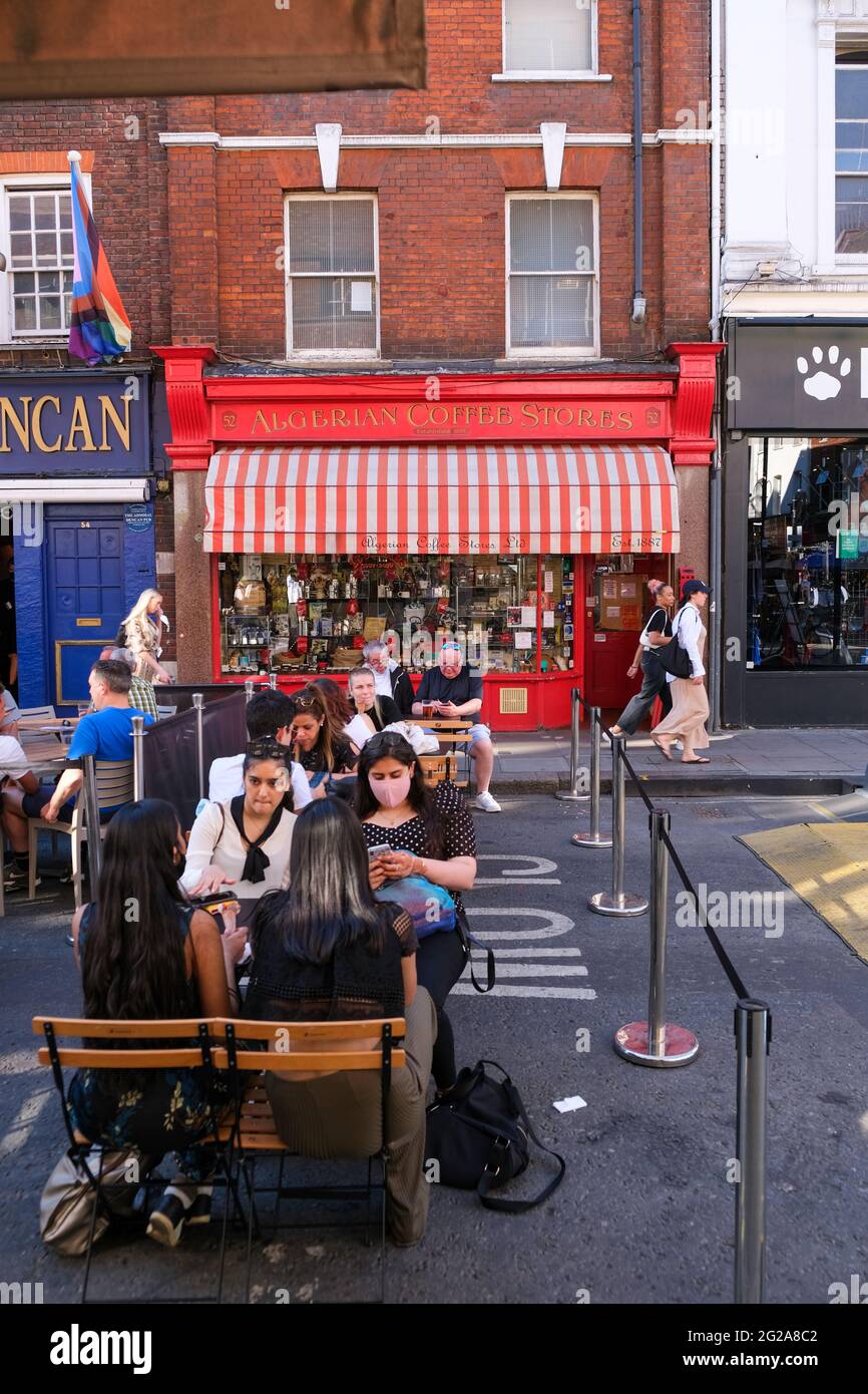 I visitatori del West End potranno godersi una calda giornata estiva durante l'eliminazione delle restrizioni della pandemia del Covid-19, Old Comton Street, Londra, Regno Unito Foto Stock