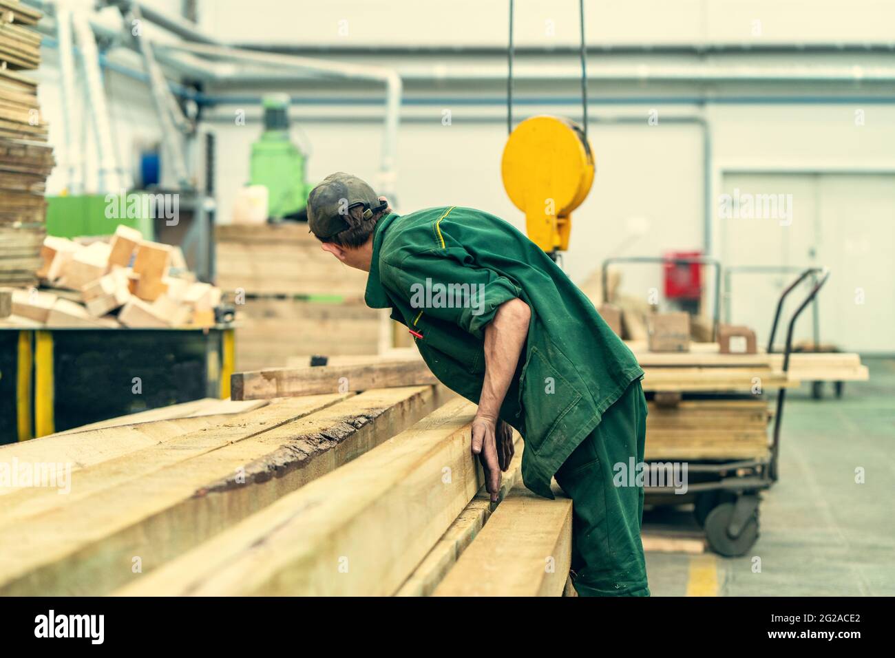 Operaio irriconoscibile in officina di legno presso l'impianto di lavorazione del legno. Foto Stock