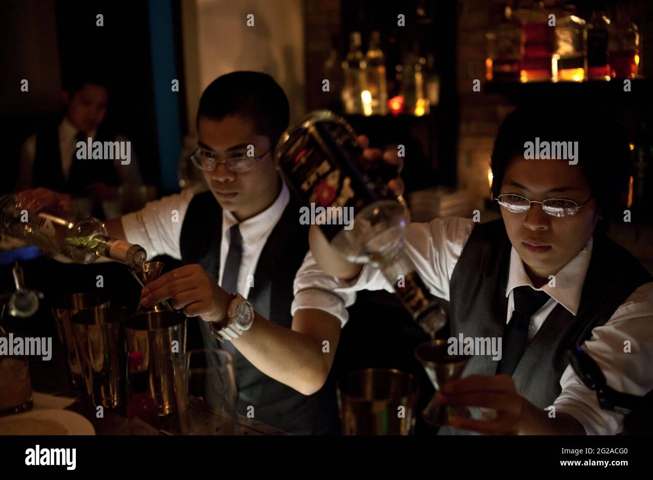 Un barman e un barman preparano cocktail al Blind Pig, un bar a Makati, Manila Foto Stock