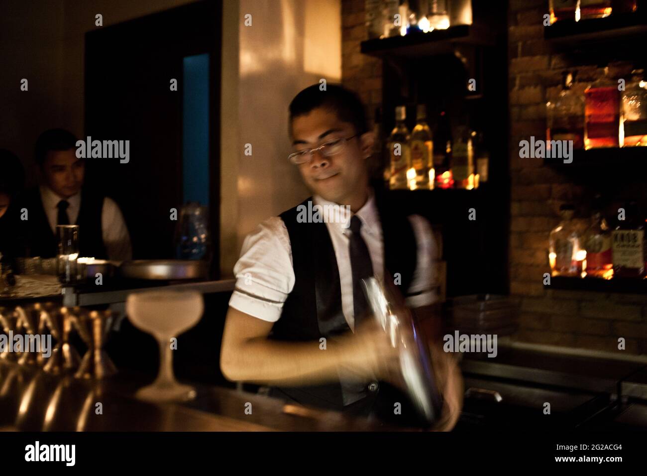 Un barman prepara cocktail al Blind Pig, un bar a Makati, Manila Foto Stock